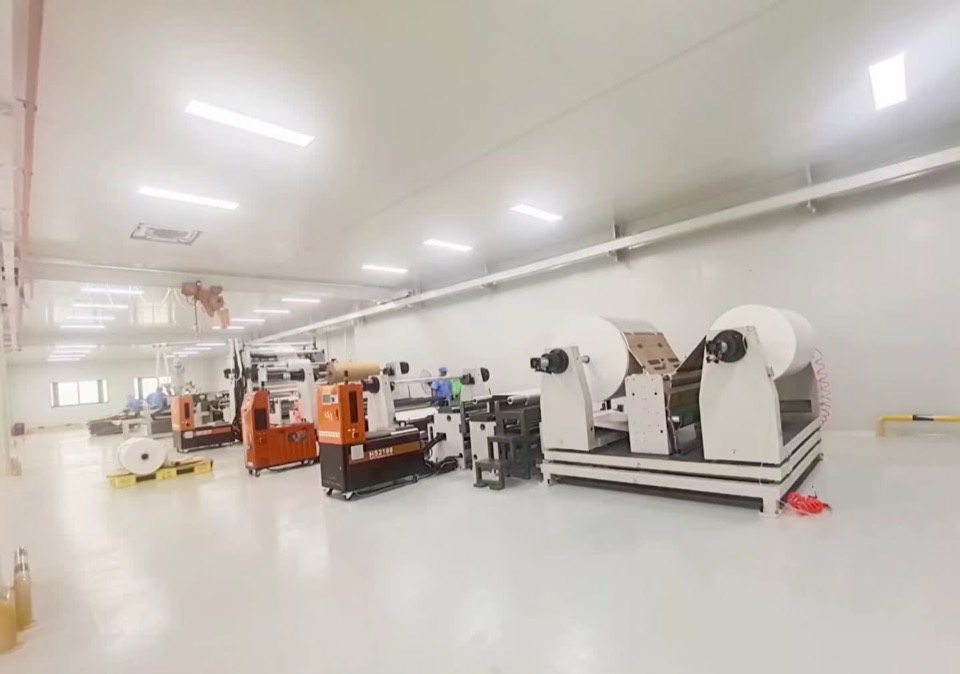 Slitting and rewinding line with white roll stock in a bright clean hall