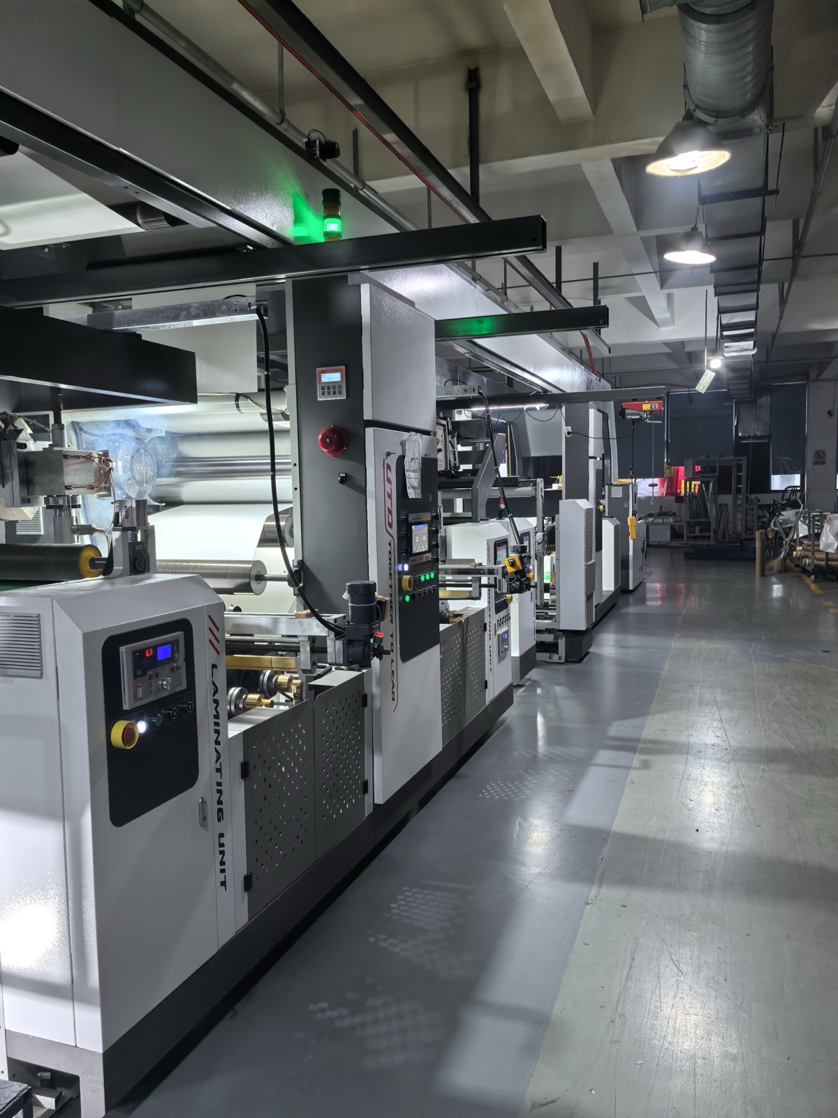 Row of laminating units with white web and lit green status lights
