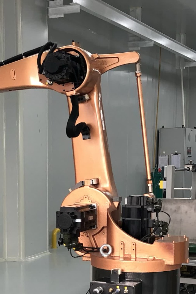 Six-axis articulated robot arm on a pedestal in a white-panelled hall